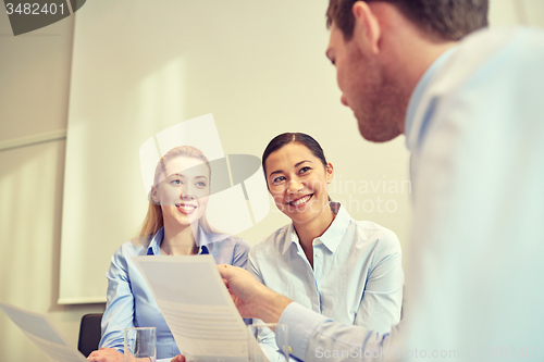 Image of group of smiling businesspeople meeting in office