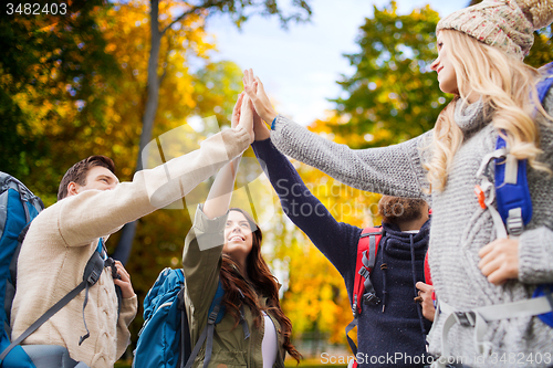 Image of group of smiling friends with backpacks hiking