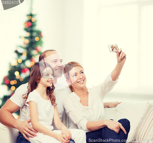 Image of happy family with camera at home