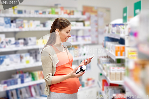 Image of happy pregnant woman with smartphone at pharmacy