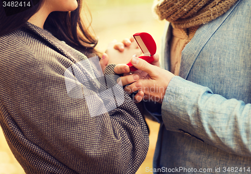 Image of close up of couple with gift box in park