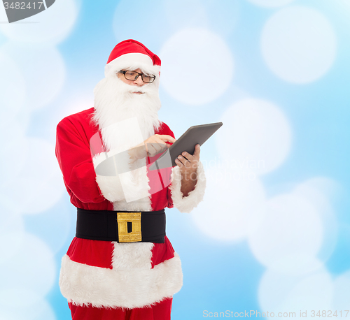 Image of man in costume of santa claus with tablet pc