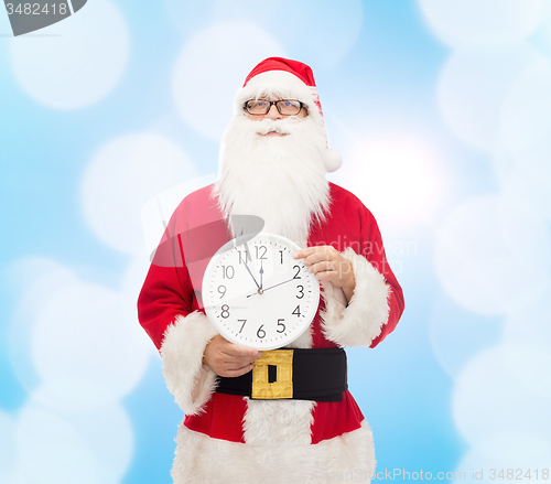 Image of man in costume of santa claus with clock