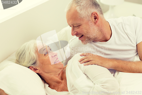 Image of happy senior coupler lying in bad at home