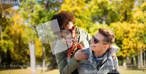 Image of happy teenage couple in shades having fun outdoors