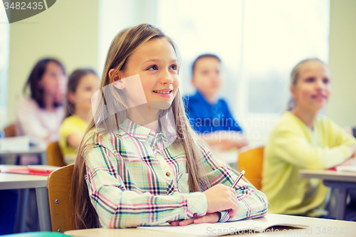 Image of group of school kids with notebooks in classroom