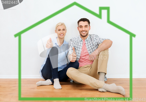 Image of happy couple showing thumbs up at new home