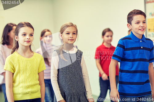 Image of group of smiling school kids walking in corridor