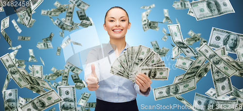 Image of smiling businesswoman with money showing thumbs up