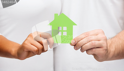 Image of couple hands holding green house