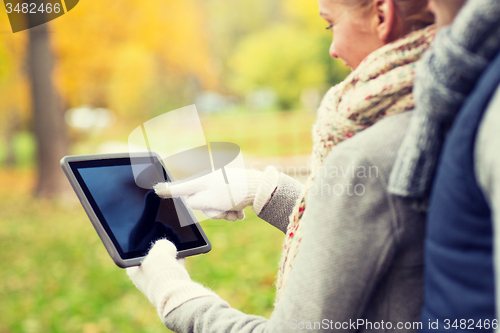 Image of couple hands in gloves with tablet pc outdoors