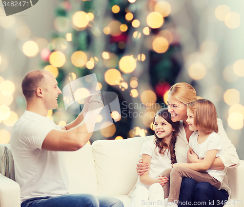 Image of happy family with camera at home