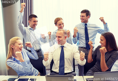 Image of business people celebrating victory in office