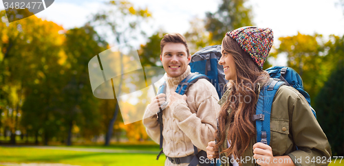 Image of smiling couple with backpacks hiking