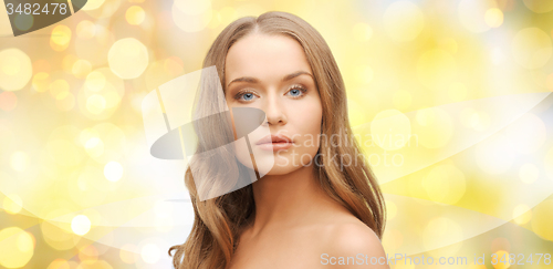 Image of beautiful young woman face over yellow lights