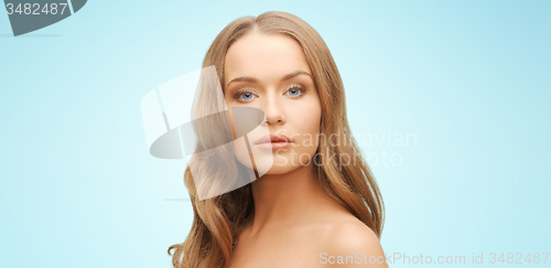 Image of beautiful young woman face over blue background