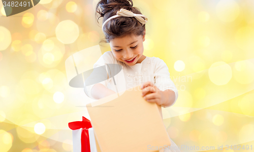 Image of smiling little girl opening gift box