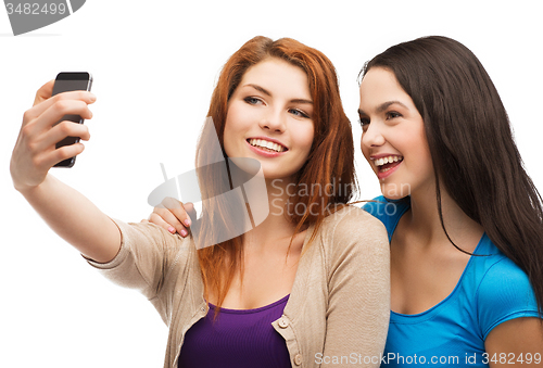 Image of two smiling teenagers with smartphone