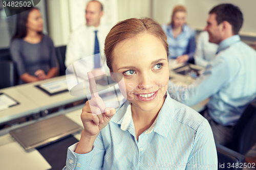 Image of group of smiling businesspeople meeting in office