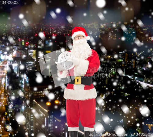 Image of man in costume of santa claus with clock