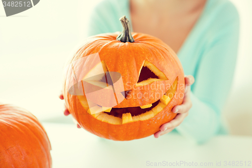 Image of close up of woman with pumpkins at home