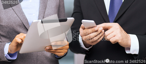 Image of two businesspeople with smartphone and tablet pc