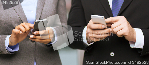 Image of businessman and businesswoman with smartphones