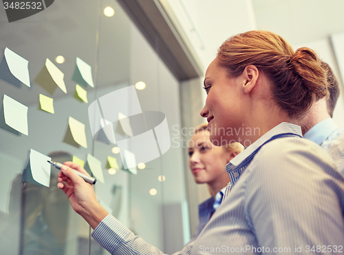 Image of smiling business people with marker and stickers