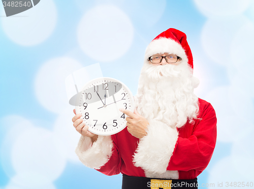 Image of man in costume of santa claus with clock