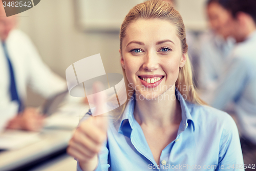 Image of group of smiling businesspeople meeting in office