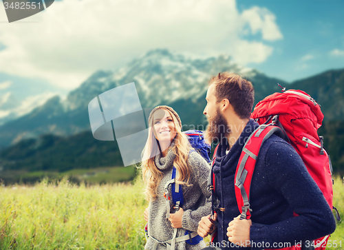 Image of smiling couple with backpacks hiking