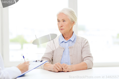 Image of doctor with clipboard and senior woman at hospital