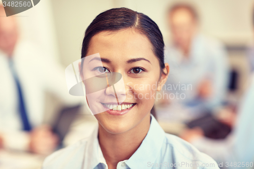 Image of group of smiling businesspeople meeting in office