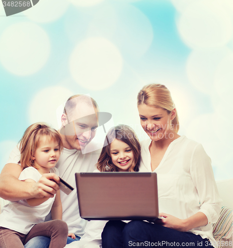 Image of happy family with laptop computer and credit card