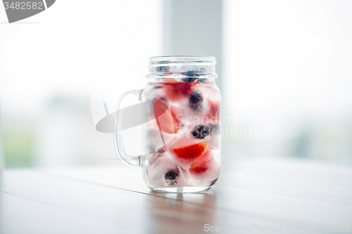 Image of close up of fruit water in glass mug on table