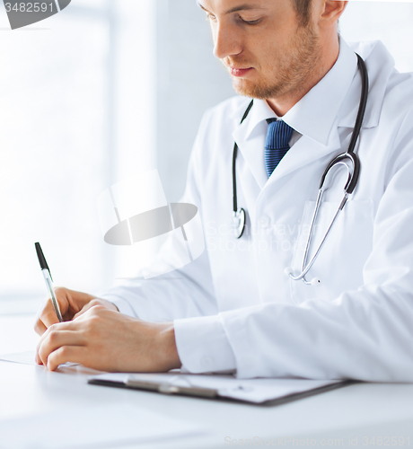 Image of patient and doctor taking notes
