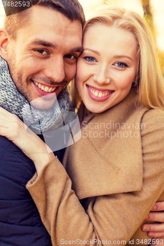 Image of smiling couple hugging in autumn park