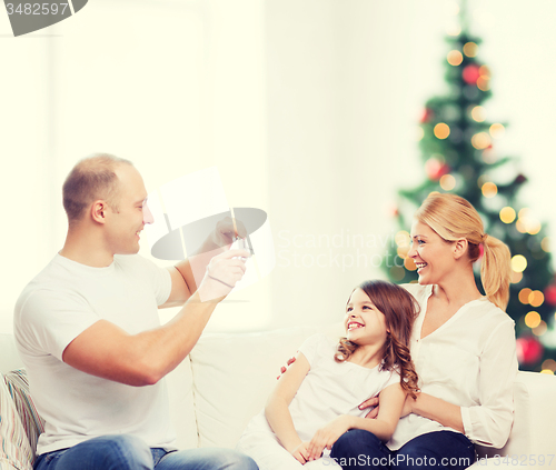 Image of happy family with camera at home