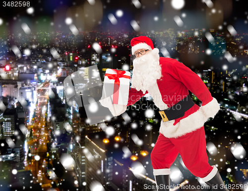 Image of man in costume of santa claus with gift box