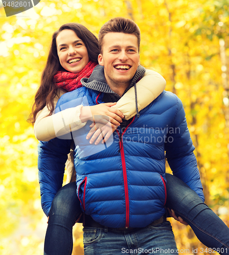 Image of smiling friends having fun in autumn park
