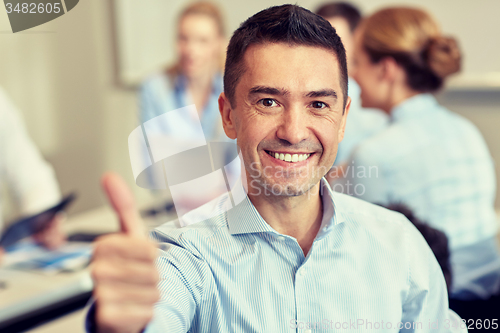 Image of group of smiling businesspeople meeting in office