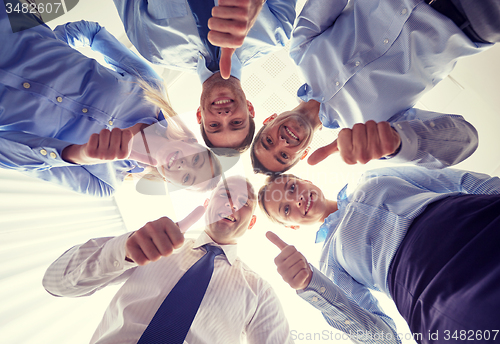 Image of smiling group of businesspeople standing in circle