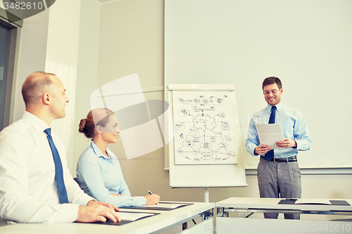 Image of group of smiling businesspeople meeting in office