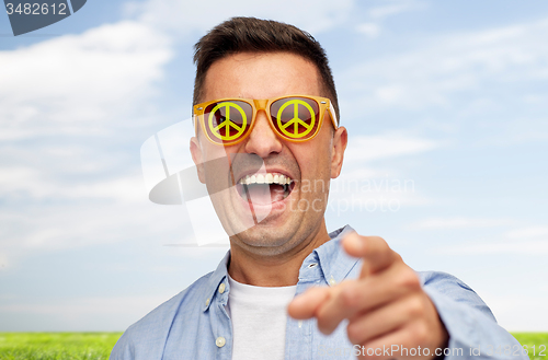 Image of face of laughing man in green peace sunglasses