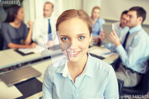 Image of group of smiling businesspeople meeting in office