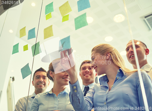 Image of smiling business people with marker and stickers