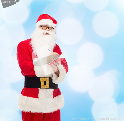 Image of man in costume of santa claus with notepad