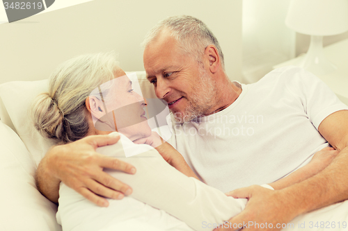 Image of happy senior coupler lying in bad at home