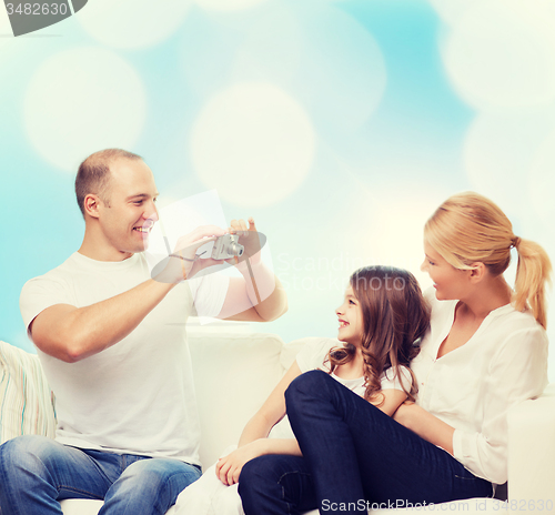 Image of happy family with camera at home