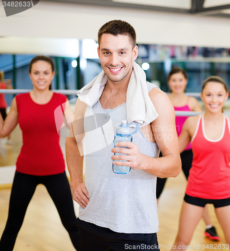 Image of smiling trainer in front of group of people